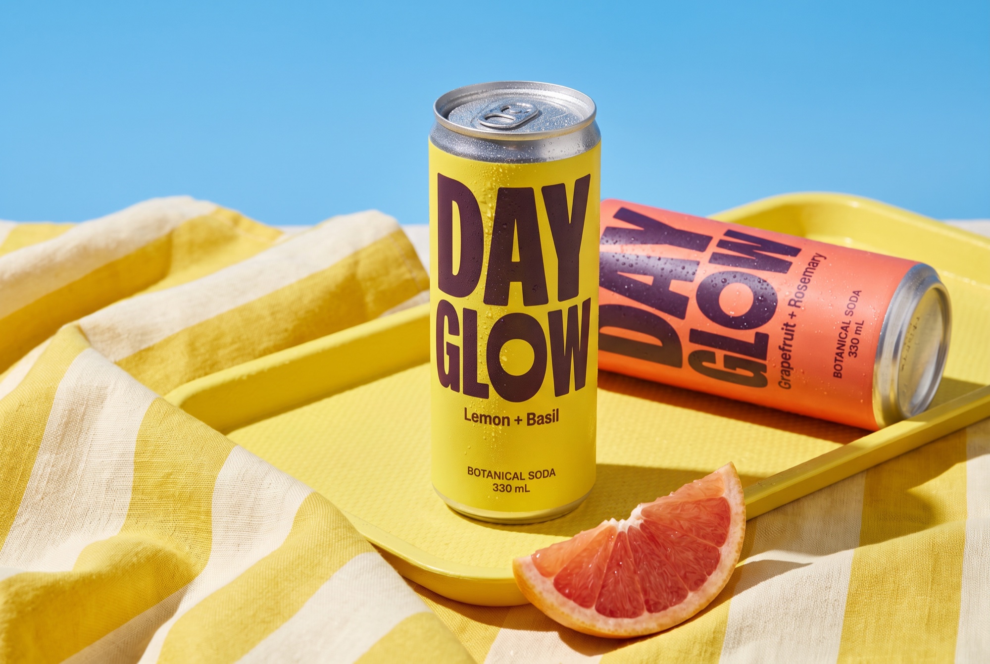 DAYGLOW botanical soda in an outdoor picnic campaign scene.